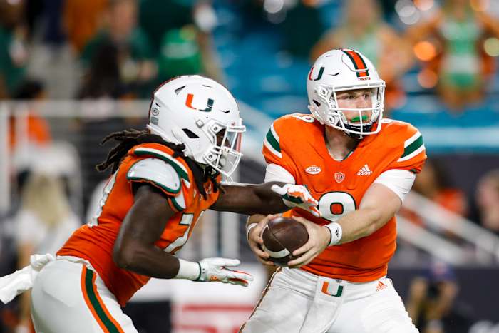 Miami’s Tyler Van Dyke hands the ball off.